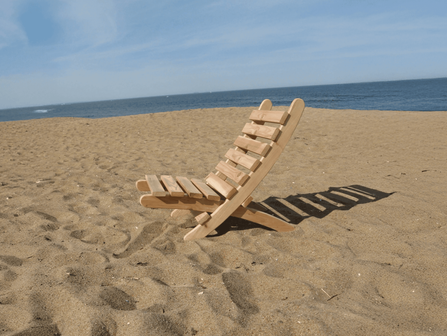 Bulky wooden beach chair on the sand near the ocean — difficult to carry and uncomfortable design